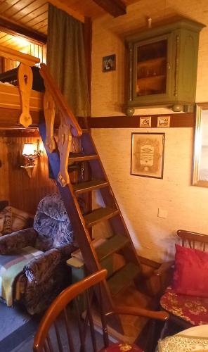 a wooden spiral staircase in a room with a couch at Arode Hütte Harzilein - Romantic tiny house on the edge of the forest in Zorge