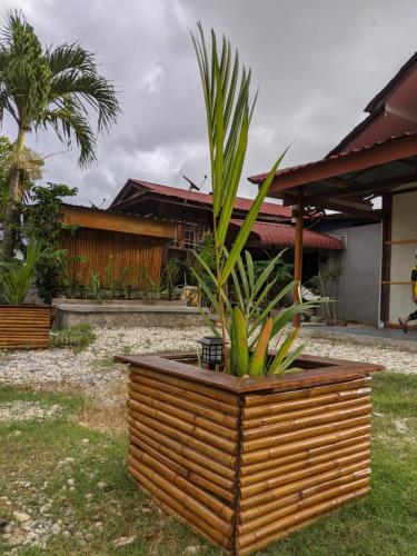 eine Pflanze in einem Holzpflanzen vor einem Haus in der Unterkunft Denai Senja in Kuala Selangor