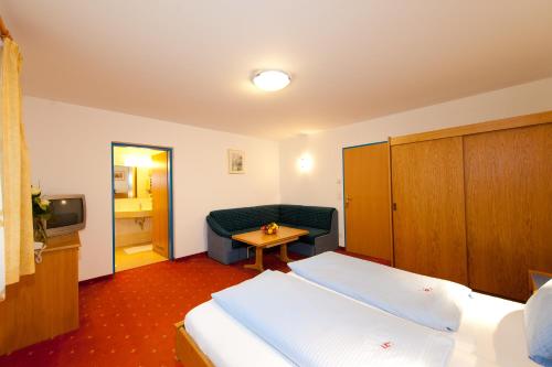 a hotel room with two beds and a couch at der Steinerwirt in Wagrain
