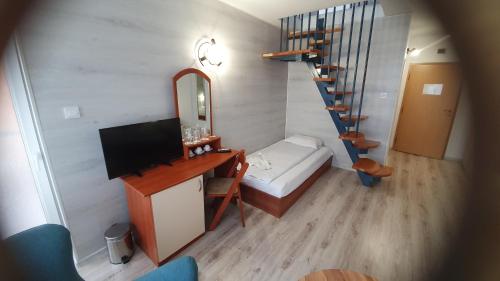 a small room with a bed and a desk and a staircase at Sea Horse in Burgas City