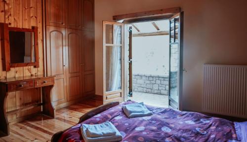 a bedroom with a bed and a sliding glass door at Mezonetes Helmos in Áno Lousoí