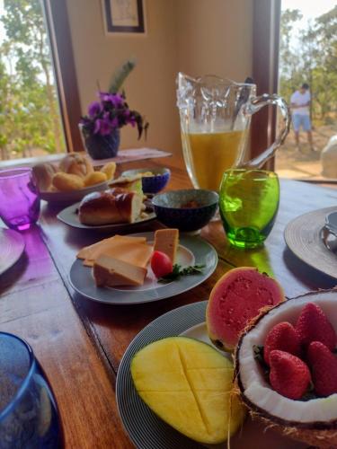un tavolo in legno con piatti di cibo e bevande di Casa Candeia a Diamantina