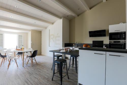 une cuisine et une salle à manger avec une table et des chaises dans l'établissement Appartement lumineux pour 6 personnes, au Bois-Plage-en-Ré