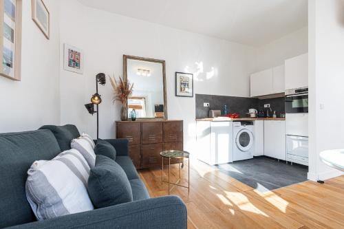 un salon avec un canapé bleu et une cuisine dans l'établissement 1 Bdr Downtown near Place Massena, à Nice