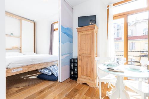 une petite chambre avec un lit et une table dans l'établissement 1 Bdr Downtown near Place Massena, à Nice
