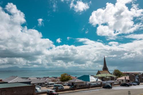 una ciudad con una iglesia y un cielo azul con nubes en Sandstone Manor, en Mossel Bay