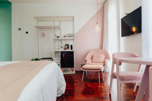 a bedroom with a bed and a table and chairs at LOTE20 Hotel Boutique in Bento Gonçalves