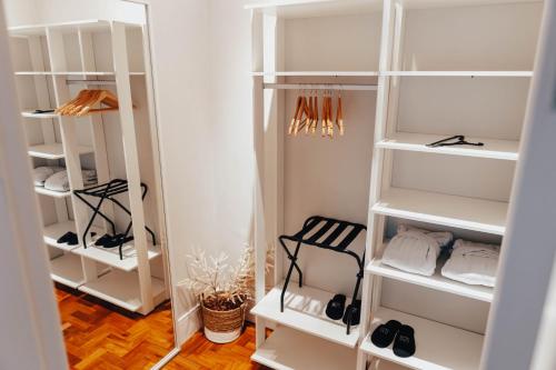a walk in closet with white shelves and shoes at LOTE20 Hotel Boutique in Bento Gonçalves