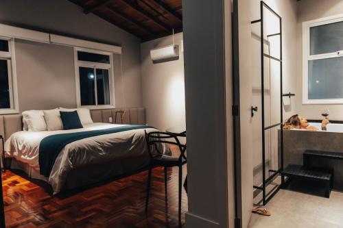 a bedroom with a bed and a tub and a girl in a bath tub at LOTE20 Hotel Boutique in Bento Gonçalves