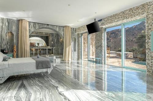 a bedroom with a bed and a wall of windows at Calilo in Manganari