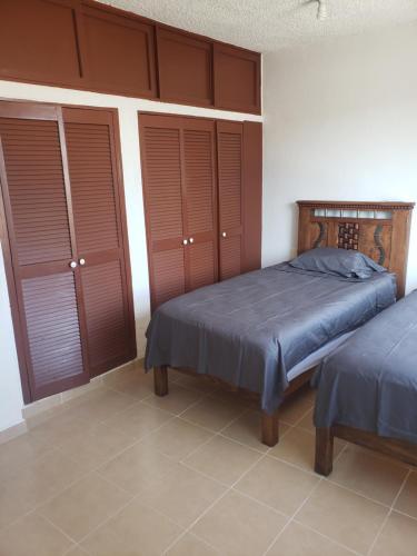 a bedroom with two beds and brown shutters at ACAPULCO DIAMANTE NUEVA E INCREIBLE VILLA CON ALBERCA PROPIA in Acapulco