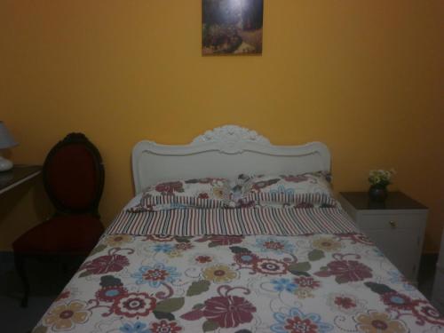a bedroom with a bed with a floral bedspread at Strenua - Las Quintanas in Trujillo