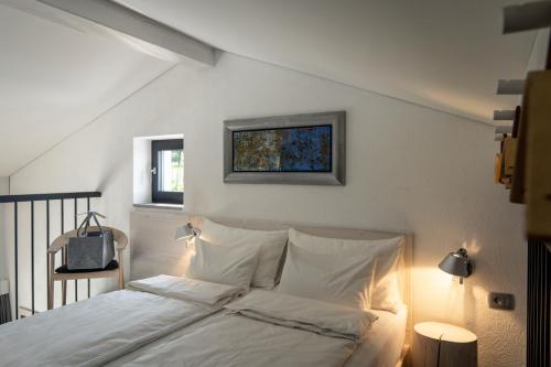 een slaapkamer met een wit bed met een foto aan de muur bij House Artes in Branik