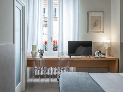 a bedroom with a desk with a computer and a window at Maison boutique Matteotti in Matera