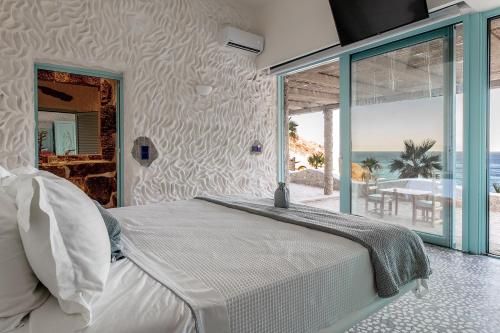 a bedroom with a bed and a view of the ocean at Calilo in Manganari