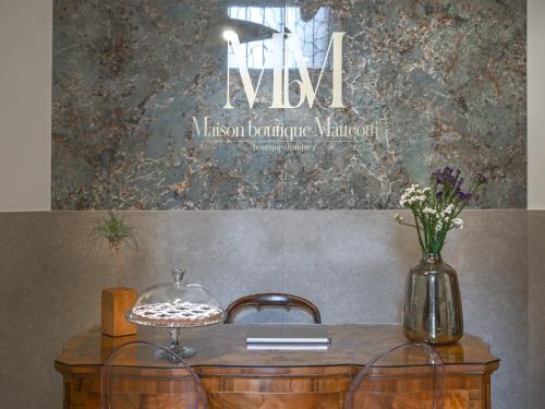 a table with two chairs and a vase on it at Maison boutique Matteotti in Matera
