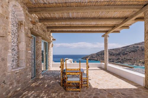 a pair of chairs sitting on a porch looking out at the ocean at Calilo in Manganari