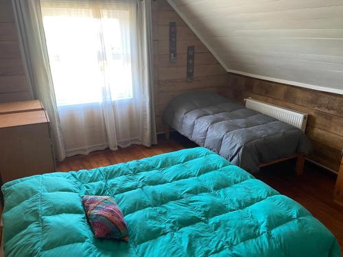 a bedroom with a bed and a window at Casa Apel Hostel in Puerto Varas