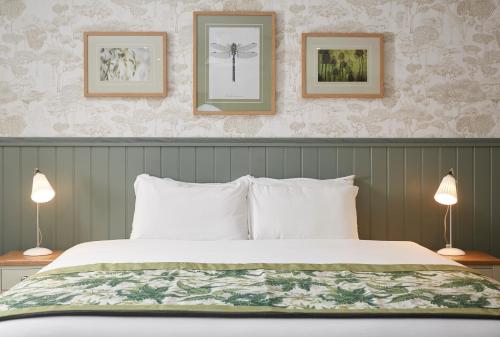 a bedroom with a large bed with two lamps at Governors House by Greene King Inns in Cheadle Hulme