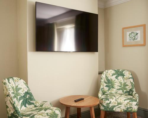 a room with two chairs and a table at Governors House by Greene King Inns in Cheadle Hulme