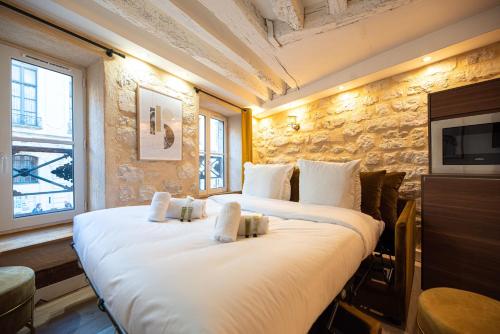 - une chambre avec 2 grands lits dans l'établissement MBM - TURENNE, à Paris