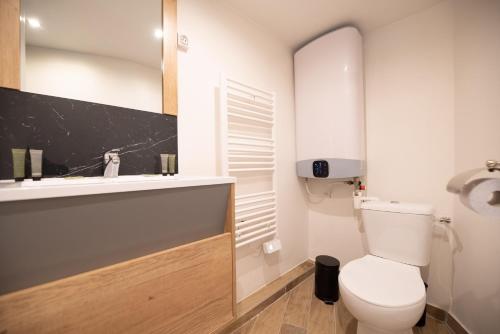 une salle de bain avec des toilettes blanches et un lavabo dans l'établissement MBM - TURENNE, à Paris