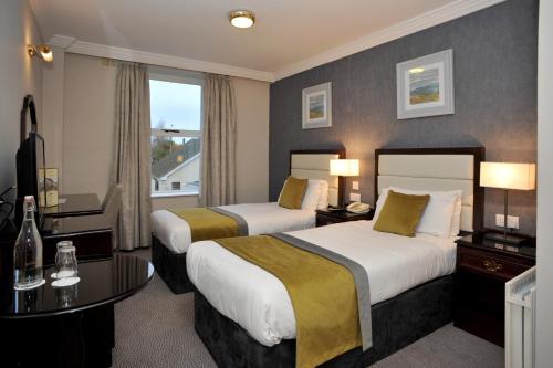 um quarto de hotel com duas camas e uma janela em Anner Hotel em Thurles