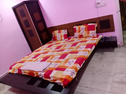 a bed with a colorful quilt on it in a room at Hotel Thakur Shri in Bhopal