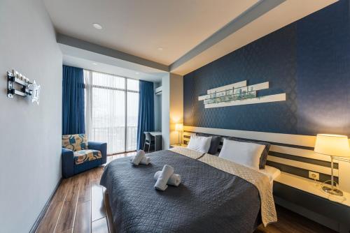 a bedroom with a large bed with two towels on it at Sani Apart Hotel in Tbilisi City