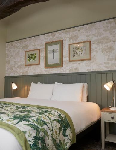 a hotel room with a bed and two pictures on the wall at Governors House by Greene King Inns in Cheadle Hulme