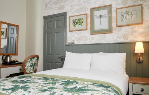 a bedroom with a bed and a table and a mirror at Governors House by Greene King Inns in Cheadle Hulme