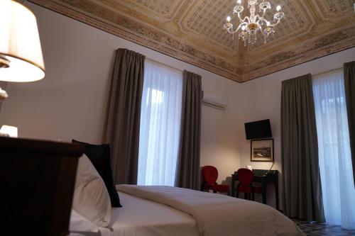 a bedroom with a bed and a chandelier at DS Apartment in Catania