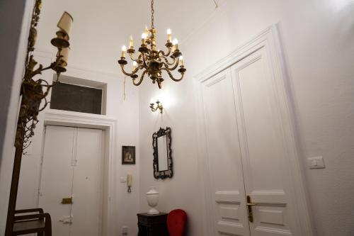 a chandelier hanging over a hallway with a door at DS Apartment in Catania