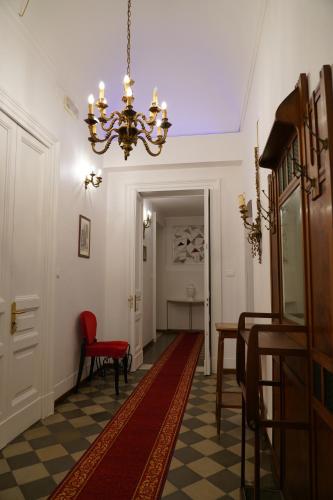 a hallway with a red chair and a chandelier at DS Apartment in Catania
