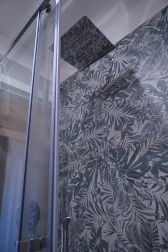 a shower stall with a blue and white wallpaper at DS Apartment in Catania