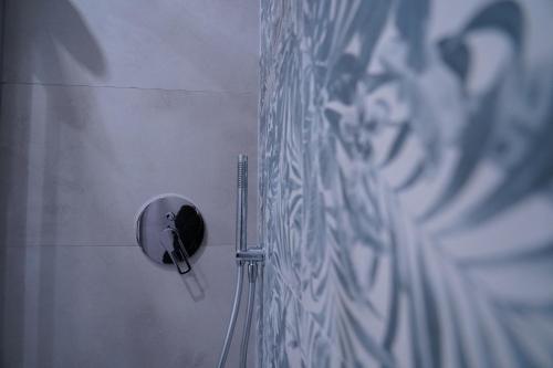 a round mirror on the wall of a bathroom at DS Apartment in Catania
