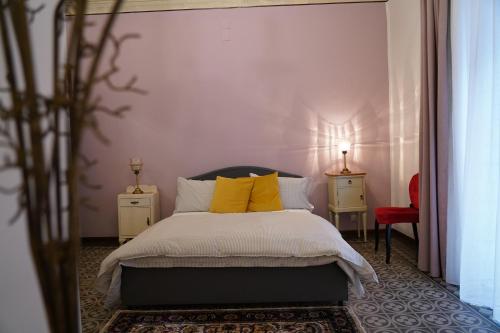 una camera da letto con letto e cuscini gialli di DS Apartments a Catania