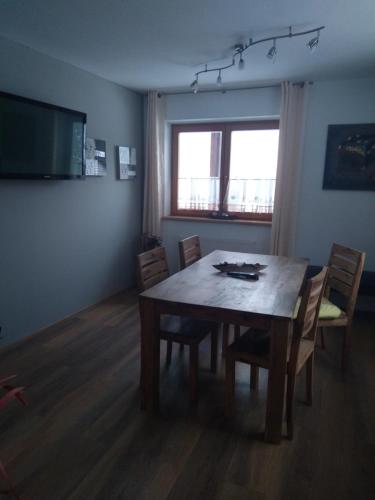 a dining room with a wooden table and chairs at Appartement Schmittenblick in Zell am See
