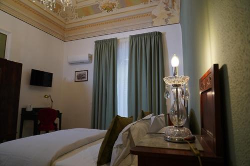 a bedroom with a bed and a lamp on a table at DS Apartment in Catania
