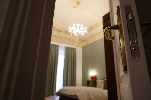 a room with a chandelier and a room with a bed at DS Apartment in Catania