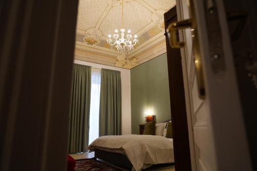 a bedroom with a bed and a chandelier at DS Apartment in Catania