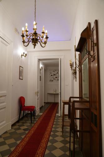 a hallway with a chandelier and a table and chairs at DS Apartment in Catania
