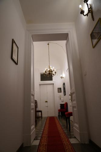 a hallway with a chandelier and a red rug at DS Apartment in Catania