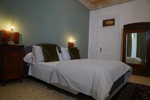 a bedroom with a bed with white sheets and pillows at DS Apartment in Catania
