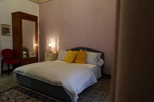 a bedroom with a bed with yellow pillows and a mirror at DS Apartment in Catania