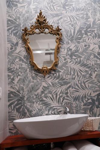 a bathroom with a mirror and a white sink at DS Apartment in Catania