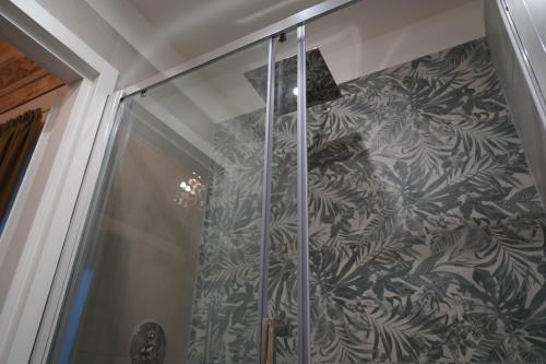 a shower stall with a black and white wallpaper at DS Apartment in Catania