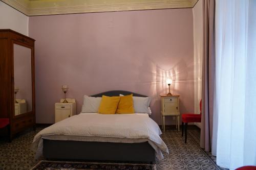 a bedroom with a bed with yellow pillows at DS Apartment in Catania