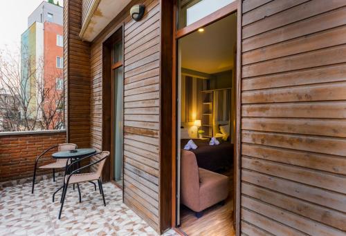 a room with a balcony with a table and a bedroom at Sani Apart Hotel in Tbilisi City