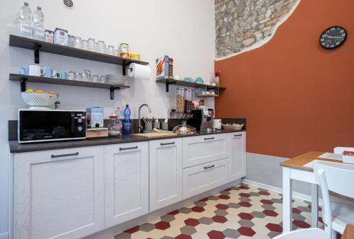 a kitchen with white cabinets and a checkered floor at b&b Casa Livia in Pordenone